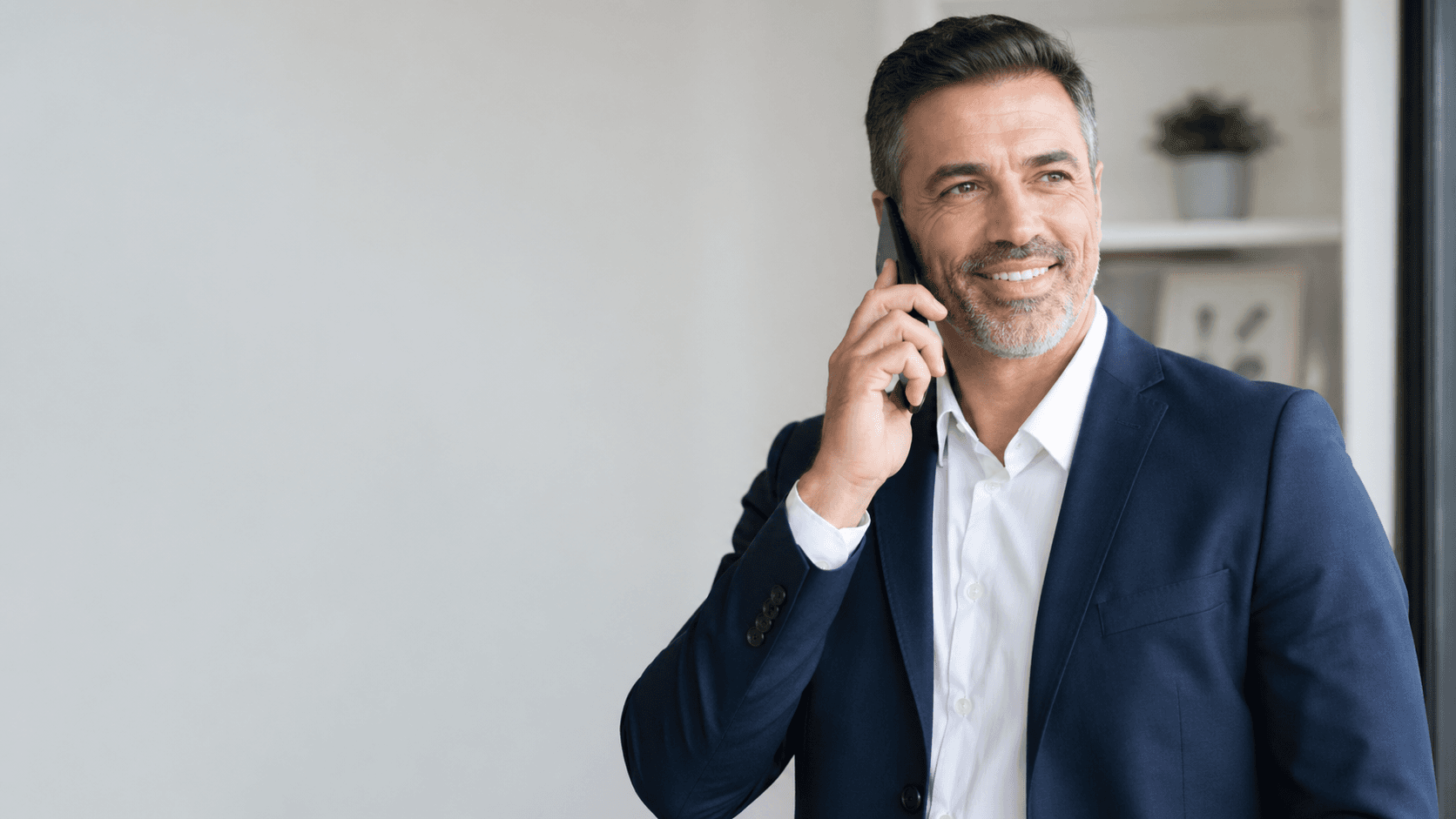 Consultor a falar ao telefone num ambiente de escritório luminoso.